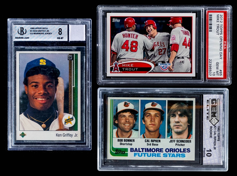 1982 Topps Baseball Card #21 Cal Ripken Jr. Rookie (GEM Elite 10), 1989 Upper Deck #1 Ken Griffey Jr. Rookie (Beckett 8) and 2012 Topps Opening Day #85 Mike Trout (PSA 10)